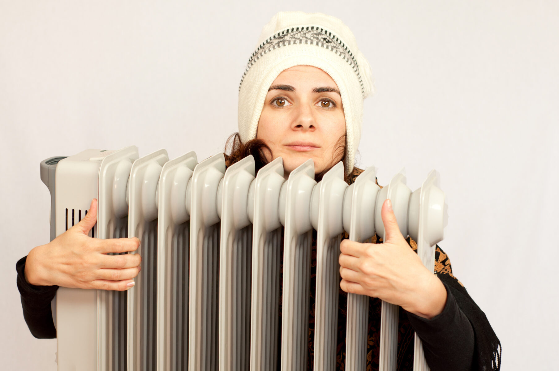 Young woman holding an electric heater